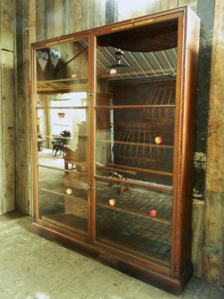 An early 20th century oak Heals glazed bookcase ex Victoria  and Albert Museum.