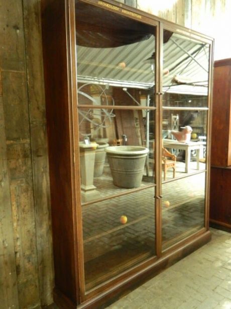 An early 20th century oak Heals glazed bookcase ex Victoria  and Albert Museum.