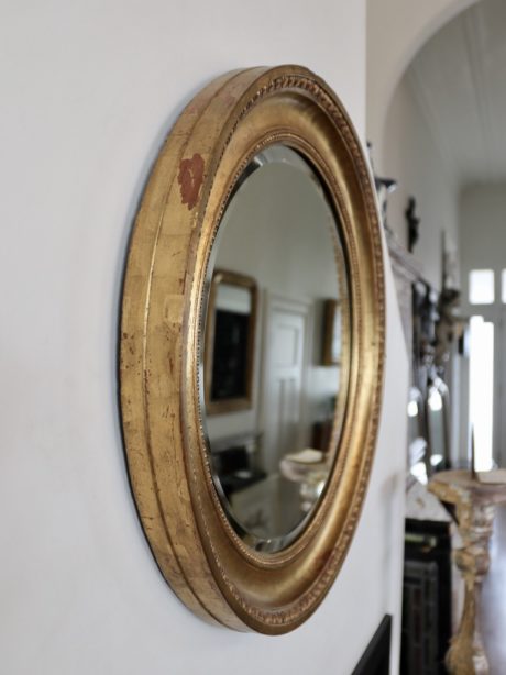 A circular porthole beveled gilt mirror