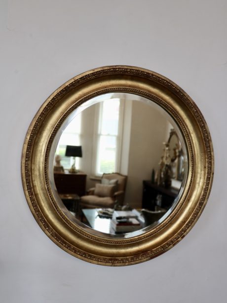 A circular porthole beveled gilt mirror